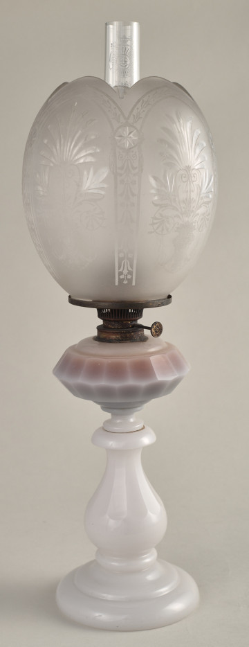 Lampa naftowa na białej szklanej stopie z kulistym matowym kloszem