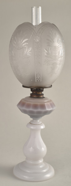 Lampa naftowa na białej szklanej stopie z kulistym matowym kloszem