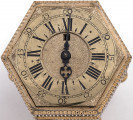 Zegar kaflak sześcioboczny. Na tarczy zegara cyfry rzymskie wskazują godziny, zaś arabskie minuty. Widok tarczy.