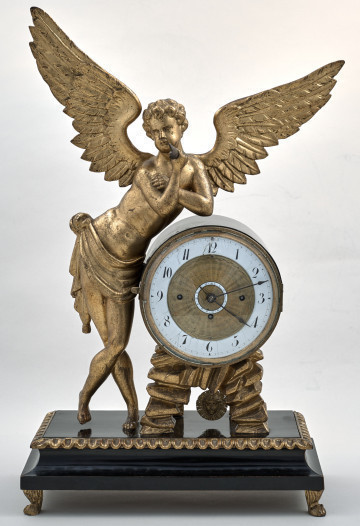Zegar kominkowy. Na niskiej podstawie pełnoplastyczna, złota postać ze skrzydłami oparta o tarczę zegarową. Ujęcie frontalne.
