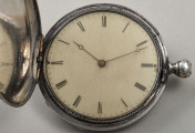 Zegarek kieszonkowy. Otwarta pokrywa ukazująca białą tarczę z czarnymi wskazówkami i cyframi rzymskimi.