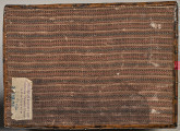 Prostokątny spód kasetki drewnianej, emaliowanej obity tkaniną z widoczną naklejką Ministerstwa Kultury i Sztuki z numerem inwentarzowym.