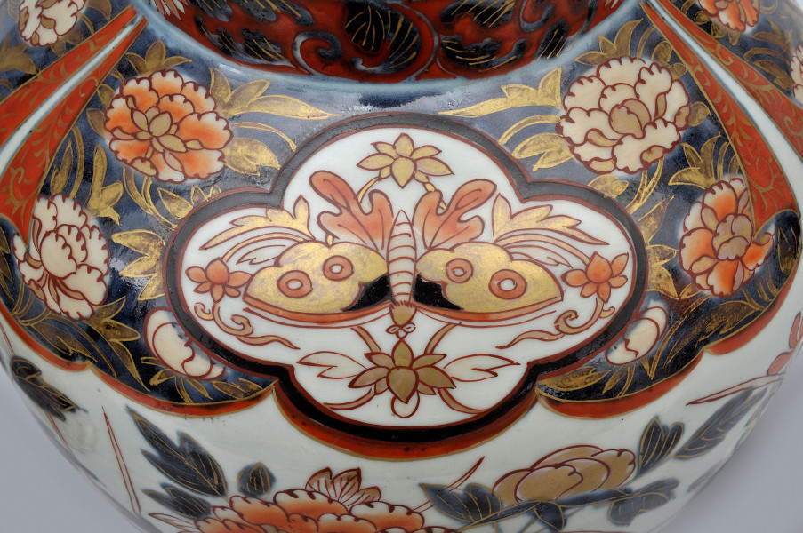 detal - dekoracja z motylem, znajdująca się w miejscu łączenia szyjki z brzuścem