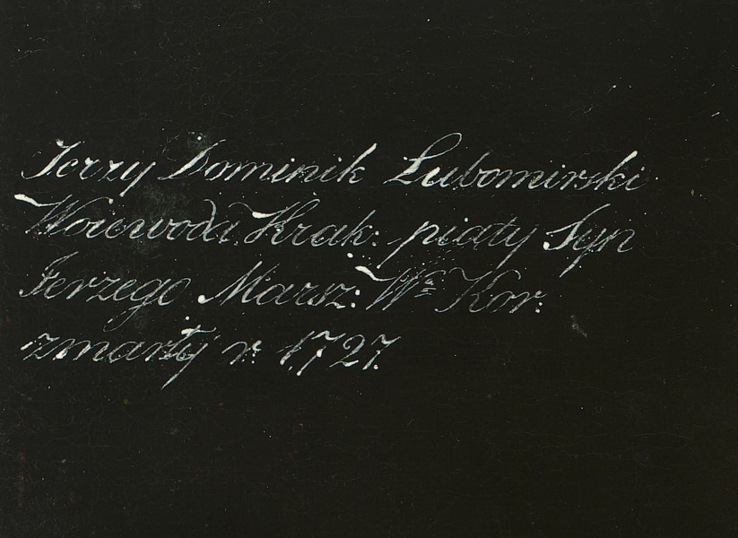 fragment lica obrazu - napis białą farbą: Jerzy Dominik Lubomirski Woiewoda Krak: piąty Syn Jerzego Marsz: W: Kor: zmarły r. 1727.