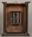 Tył zegara w formie drewnianej skrzynki z niedużym mechanizmem w środkowej części