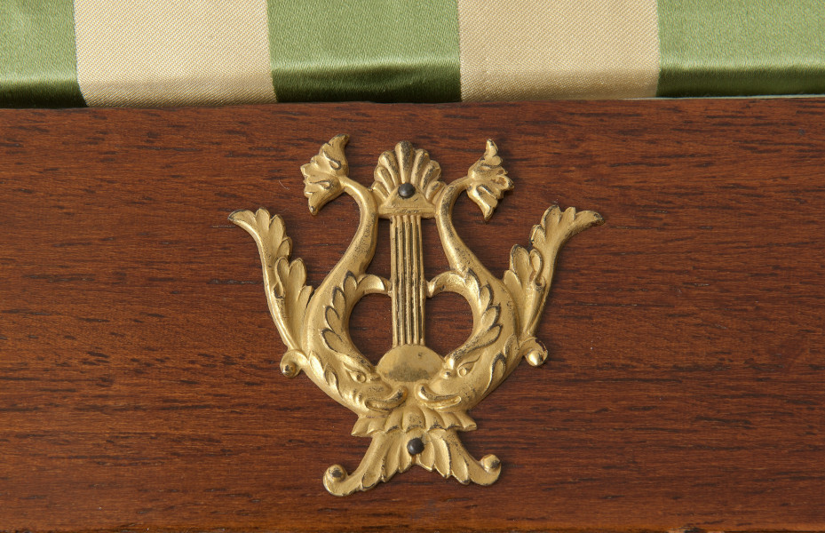 plakietka z brązu złoconego (lira) na ramiaku od strony pierwszej