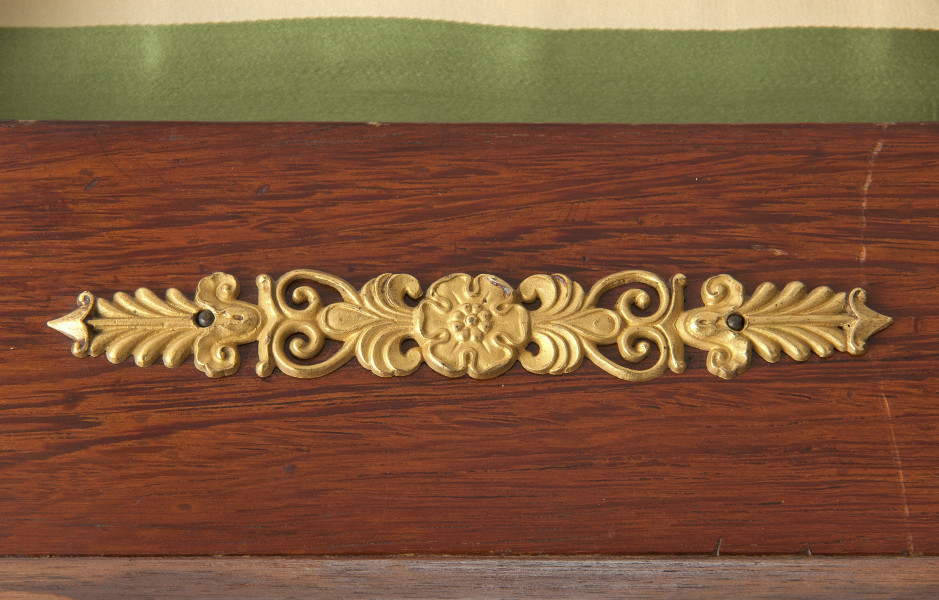 plakietka z brązu złoconego z elementami ornamentu empirowego (palmety, strzały) na ramiaku od strony czwartej