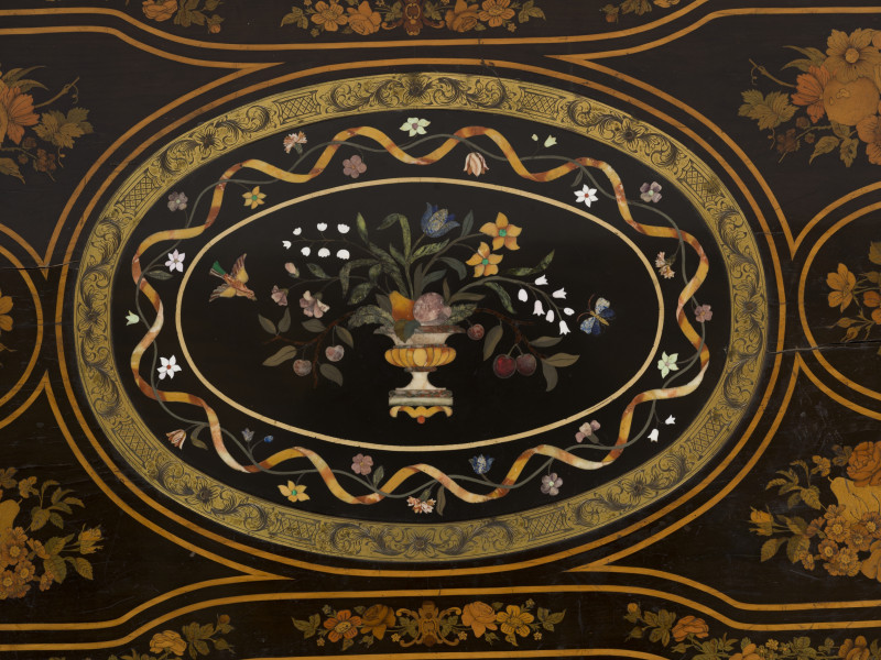 zbliżenie na dekorację blatu - owalna płyta marmurowa z inkrustacją (wazon z kwiatami, ptak i motyl) otoczona brązową cyzelowaną ramą