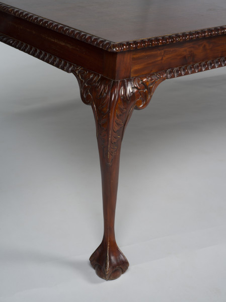 zbliżenie na prawą przednia rzeźbioną nogę stołu