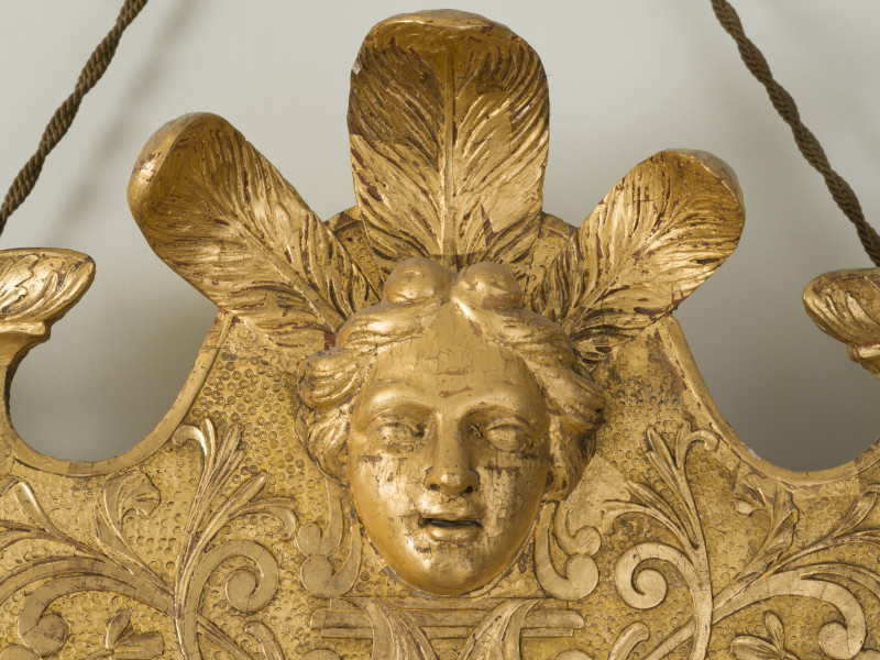 zbliżenie na rzeźbioną dekorację ramy w formie kobiecej głowy w pióropuszu