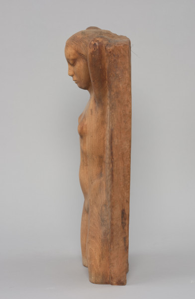 Wiosna - Ujęcie z boku z lewej strony;  Płaskorzeźba przedstawia postać nagiej kobiety z nogami uciętymi na wysokości kolan. Głowa podparta z tyłu obiema rękoma, oczy zamknięte.