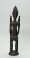 drewniana figura - Ujęcie z tyłu. Drewniana, rzeźbiona figura kobiety. Na jej ramionach i rękach znajdują się mniejsze figurki.