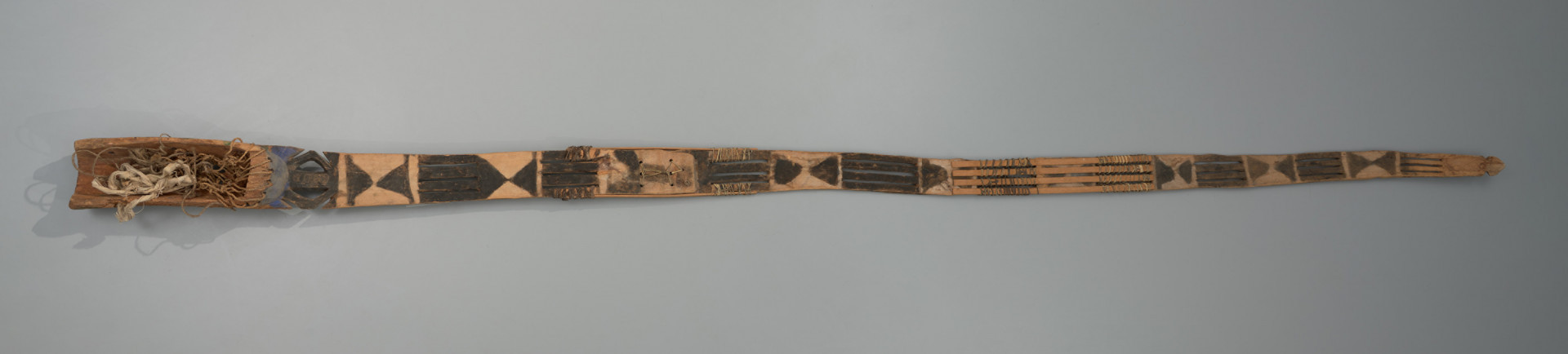 maska sirige - Ujęcie z dołu. Drewniana, rzeźbiona maska w kształcie długiej deski.