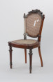 krzesło - Ujęcie z przodu, z prawej strony. Drewniane krzesło z płasko wyściełanym siedziskiem i oparciem z plecionki