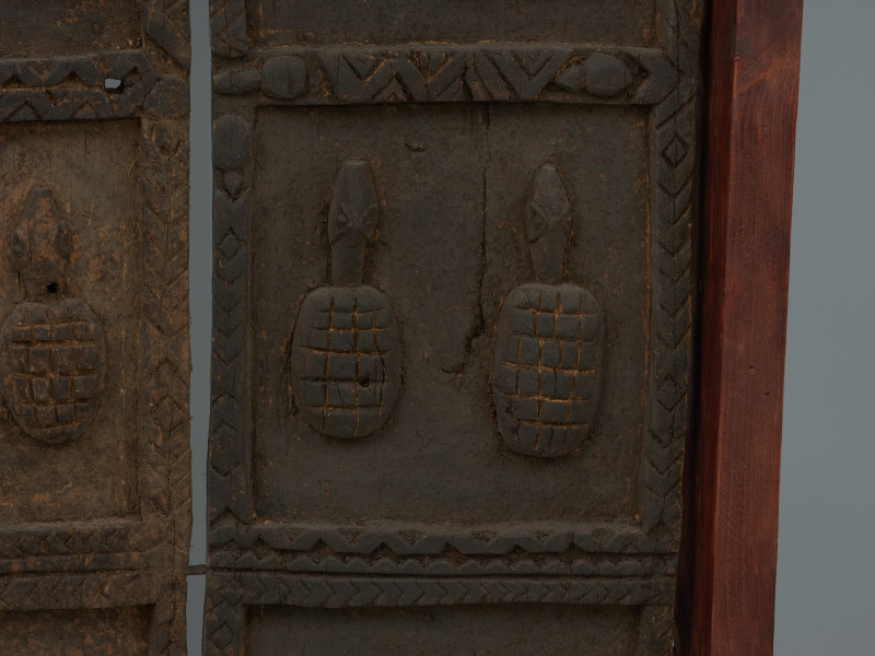 drzwi - Ujęcie szóstego detalu. Dwuczęściowe drewniane drzwiczki do spichlerza. Całość udekorowana płaskorzeźbami.