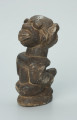 rzeźba; przedmiot obrzędowy; Figura kultu sił wegetacji - Ujęcie z tyłu. Rzeźbiona w grafitowym steatycie siedząca postać ludzka o dwóch twarzach, z przodu i z tyłu głowy.
