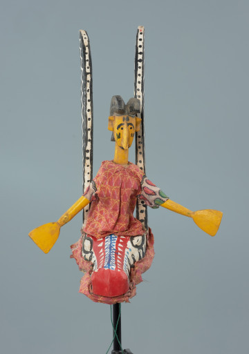lalka teatralna: Yayoroba na antylopie dajè - Ujęcie z przodu. Drewniana lalka teatralna przedstawiającą kobietę siedzącą na głowie antylopy.