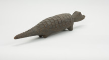 figura zoomorficzna: krokodyl - Ujęcie z tyłu skosem w prawą stronę. Drewniana, rzeźbiona figura krokodyla.