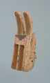 maska zająca - Ujęcie z przodu skosem w lewą stronę. Drewniana, rzeźbiona maska w kształcie zająca, którego  uszy wygięte są do przodu i wydrążone.