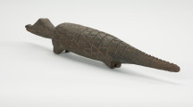 figura zoomorficzna: krokodyl - Ujęcie z tyłu skosem w lewą stronę. Drewniana, rzeźbiona figura krokodyla.