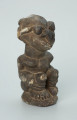 rzeźba; przedmiot obrzędowy; Figura kultu sił wegetacji - Ujęcie z przodu z prawej strony. Rzeźbiona w grafitowym steatycie siedząca postać ludzka o dwóch twarzach, z przodu i z tyłu głowy.