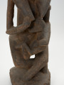 drewniana, rzeźbiona figura - Ujęcie z przodu, na dolną część. Drewniana, rzeźbiona postać kobiety, trzymającej w ramionach małe dziecko.