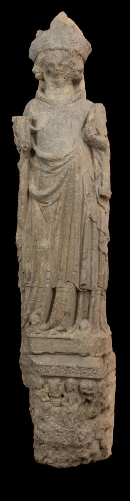 Biskup Otto z Bambergu - Ujęcie z przodu; Rzeźba wykonana jest w jednym bloku piaskowca. Przedstawia pełnoplastycznie opracowaną postać w stroju biskupa stojącego na płaskorzeźbionej przyściennej konsoli. Biskup na głowie nosi niską mitrę. Narzucony na ramiona płaszcz spięty jest czterolistną zapinką dekorowaną przedstawieniem gryfa. W zgiętych w łokciu rękach trzyma: w prawej panniselus, w lewej księgę lub fragment budowli (kształt o nieczytelnej formie). Powierzchnia szat w górnej partii rzeźby gładka, poniżej rąk, modelowana światłocieniowo równoległymi rurkowatymi fałdami. Przednia część konsoli zdobiona przedstawieniem siedzącej pary, której towarzyszą – ukazane na ściankach bocznych - postaci niewiasty i mężczyzny. Poniżej pary herb z motywem gryfa, na bokach konsoli liście winnej latorośli. Od dołu konsola zawiera przedstawienie głowy Lewiatana o otwartej paszczy. Stan dobry. Liczne obtłuczenia kamienia zwłaszcza w partii twarzy biskupa.