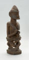 drewniana, rzeźbiona figura - Ujęcie z przodu, z prawej strony. Drewniana, rzeźbiona postać kobiety, trzymającej w ramionach małe dziecko.