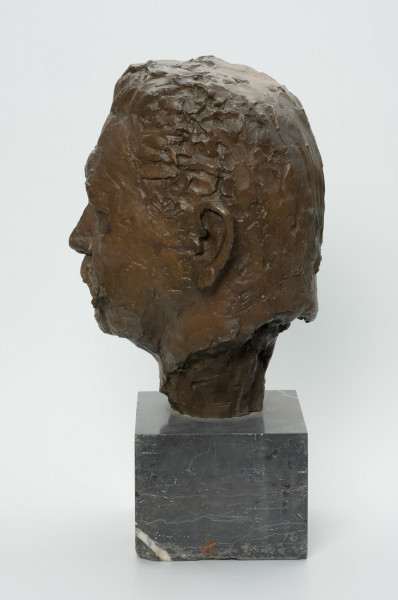 portret męski - Ujęcie z tyłu skosem w prawą stronę; Rzeżba wykonana z brązu przedstawiająca głowę męską (prezydenta Rzeszy Paula von Hindenburga). Głowa umieszczona na niedużym postumecnie.