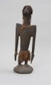 rzeźba przodka przedstawiająca dzioborożca - Ujęcie z tyłu; Drewniana, antropomorficzna rzeźba z nosem przypominającym ptasi dziób.