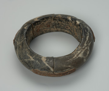 bransoleta męska - Ujęcie z przodu. Zamknięta, kamienna, okrągła bransoleta w kolorze grafitowy. Zewnętrzna powierzchnia bransolety gładka, wewnętrzna szorstka.