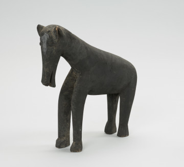 figura zoomorficzna: koń - Ujęcie z przodu skosem w lewą stronę. Drewniana, rzeźbiona figura konia.