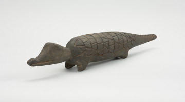 figura zoomorficzna: krokodyl - Ujęcie z przodu skosem w lewą stronę. Drewniana, rzeźbiona figura krokodyla.