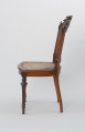 krzesło - Ujęcie z prawego boku. Drewniane krzesło z płasko wyściełanym siedziskiem i oparciem z plecionki
