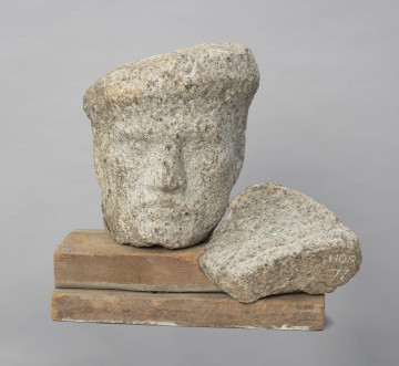 portret męski - Ujęcie z przodu; Rzeźba z kamienia przedstawiająca głowę marynarza w czapce. Rzeźba szczecińska złożona z trzech niezależnych elementów: drewnianej plinty oraz granitowych głowy i fragmentu kołnierza.