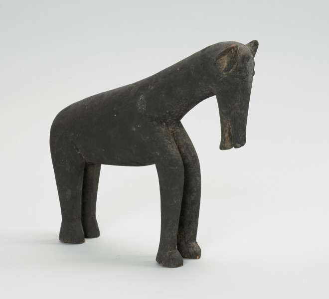 figura zoomorficzna: koń - Ujęcie z przodu skosem w prawą stronę. Drewniana, rzeźbiona figura konia.