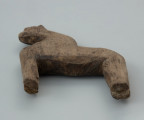przedmiot kultowy, figurka - Ujęcie z dołu w poziomie. Drewniana figurka antropomorficzna jednotwarzowa, ze schematycznie zaznaczonymi kończynami, tzw. idol, została wyciosana z jednego kawałka drewna.