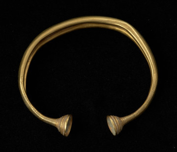 bransoleta z pieczątkowatymi zakończeniami - Ujęcie z góry tyłu. Bransoleta złota z pieczątkowatymi zakończeniami, którą zdobi żebrowanie, grupy nacięć oraz zygzaki.