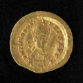 moneta; Złoty solid cesarza Teodozjusza II - Ujęcie awersu. Złoty solid cesarza Teodozjusza II. Powierzchnie są nieco starte, ale treść awersu i rewersu jest czytelna.