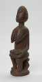 rzeźba - Ujęcie z przodu z lewej strony. Drewniana, rzeźbiona postać z dzieckiem w pozycji siedzącej. Figura pokryta drobnym, dekoracyjnym rytem. Dziecko leżące w pozycji embrionalnej. Ramiona kobiety zaokrąglone.