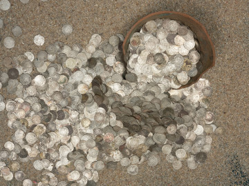 skarb monet - Ujęcie naczynia i wysypujących się monet. Skarb 3311 drobnych monet, głównie pomorskich szelągów podwójnych, ukryty w naczyniu glinianym po 1660 roku.