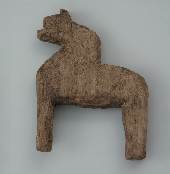 przedmiot kultowy, figurka - Ujęcie prawego boku z góry. Drewniana figurka antropomorficzna jednotwarzowa, ze schematycznie zaznaczonymi kończynami, tzw. idol, została wyciosana z jednego kawałka drewna.