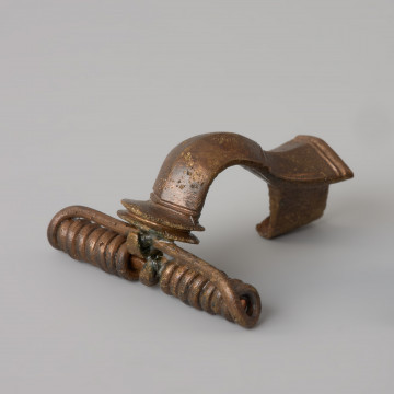 ozdoba; Zapinka z rodziny zapinek z charakterystycznym grzebykiem - Ujęcie z przoduz lewej strony. Zapinka z brązu.