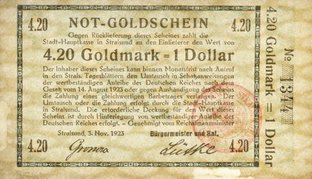 bon - Ujęcie z przodu z poddrukiem Jednostronny bon o nominałe 4,20 złotej marki = 1 dolar, z błękitnym poddrukiem, czarnymi napisami i bordową pieczęcią.