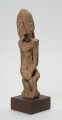 rzeźba - Ujęcie ze skosu z prawej; Figura - postać mężczyzny w pozycji stojącej. O płci świadczy bródka. Części ciała płaskorzeźbione z bryły. Forma uproszczona, zgeometryzowana. Związana z kultem przodków, przeznaczona na ołtarz przodków.