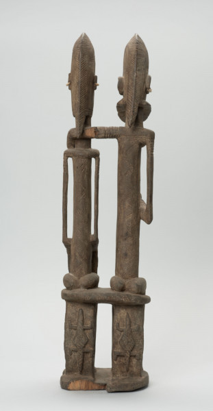 rzeźba - Ujęcie z tyłu; Figura - para przodków -  mężczyzny i kobiety. Oboje ujęci w pozycji siedzącej. Postacie smukłe. Mężczyzna obejmuje lewą ręką kobietę. Związana z kultem przodków. Na krzesłach u dołu rzeźbione postacie jaszczurek.