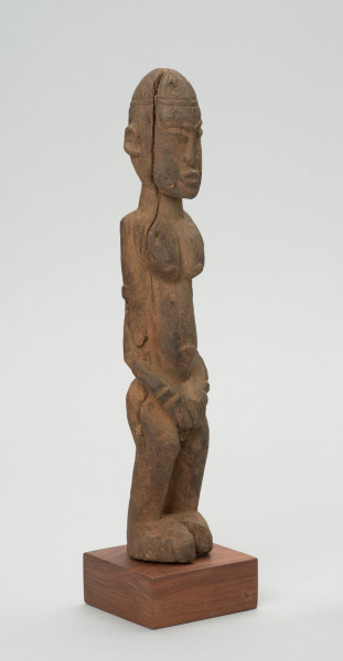 rzeźba - Ujęcie ze skosu z lewej; Figura - postać przodka w pozycji stojącej. Głowa podłużna, zaokrąglona. Rysy 