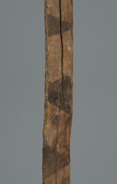 maska imina - Ujęcie detalu środkowej części. Drewniana, długa, pionowa maska, pomalowana w czarne trójkąty.