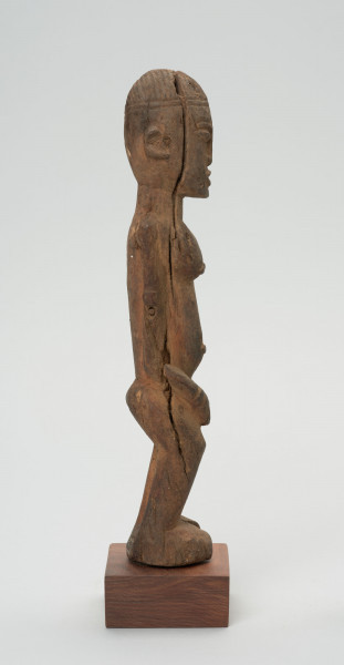rzeźba - Ujęcie z lewego boku; Figura - postać przodka w pozycji stojącej. Głowa podłużna, zaokrąglona. Rysy 