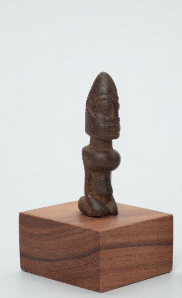 rzeźba - Ujęcie przodu i boku; Figura - postać przodka przedstawiająca przodka w pozycji siedzącej (klęczącej?) na ugiętych w kolanach nogach. Głowa duża, ok. ? powierzchni figurki. Wyraźnie zaznaczone rysy 
